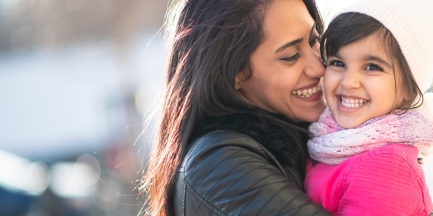 A mother carrying her young daugther.